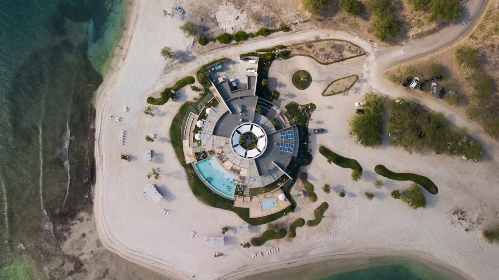 Aerial view of a unique and modern beach house built on an island