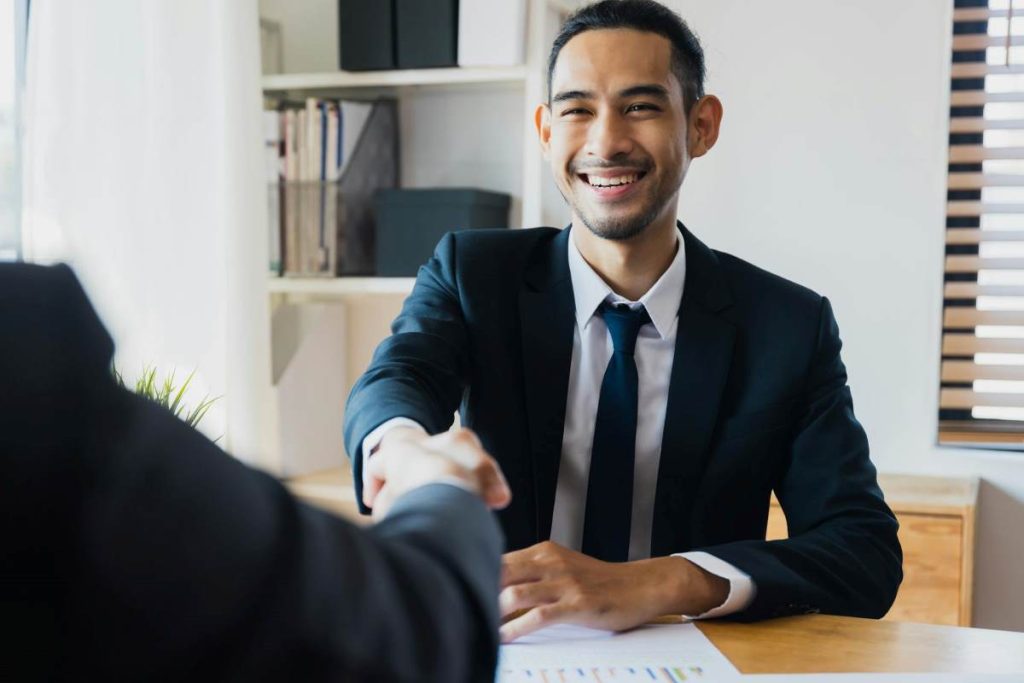 Business partners shaking hands over real estate development agreements.