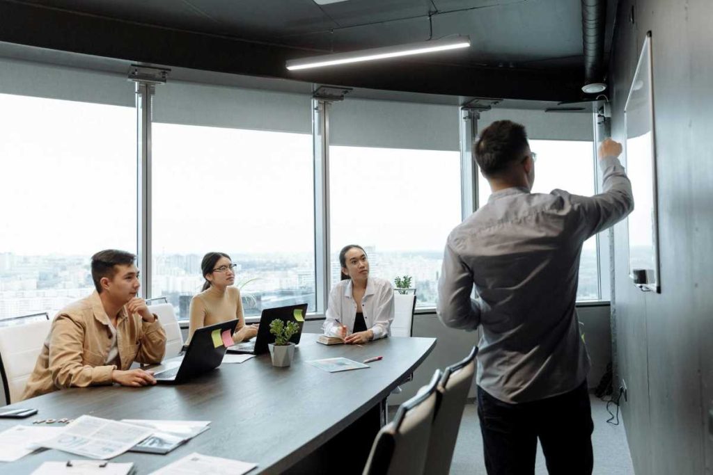 Business professionals in a boardroom discussing investments, representing streamlined investment procedures.