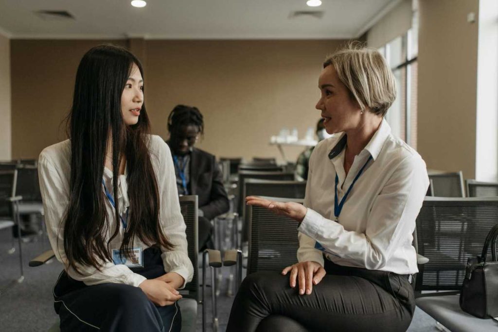 Two female delegates networking at an international conference in the Philippines.